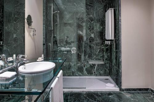 a black and white bathroom with a sink and a shower at AC Hotel Tarragona by Marriott in Tarragona