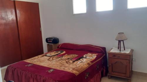 1 dormitorio con 1 cama con colcha roja en Departamento por día in 