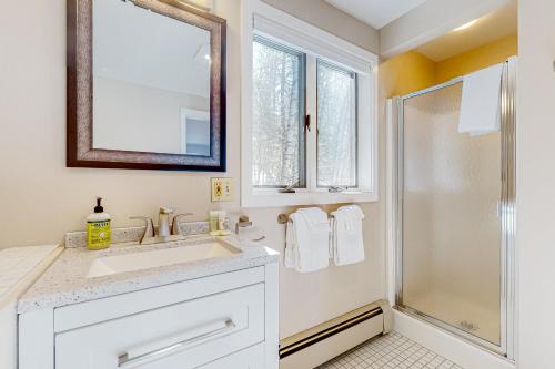 a white bathroom with a sink and a shower at Tin Mountain Treetops Time in Jackson