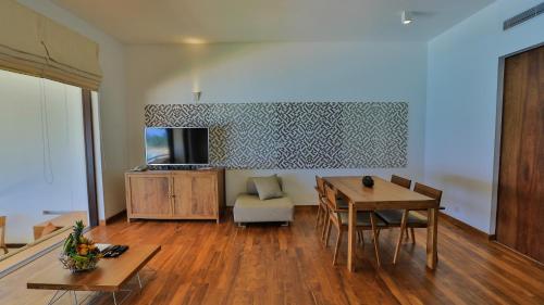 a living room with a table and a dining room at Pandanus Beach Resort & Spa in Bentota
