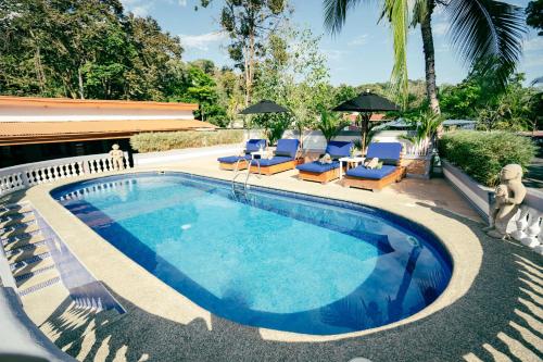 una piscina con tumbonas y una piscina en Hotel Villabosque Eco Boutique, en Manuel Antonio