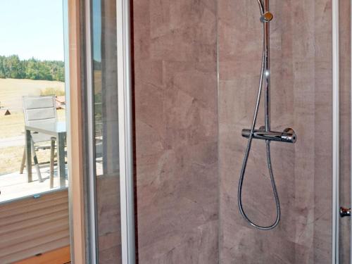 a shower with a hose attached to a glass door at Eco-friendly detached tiny house in the Black Forest on huge property 