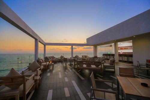 a restaurant with a view of the ocean at sunset at Pandanus Beach Resort & Spa in Bentota