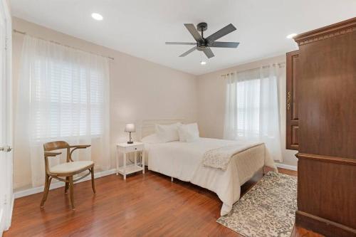 a white bedroom with a bed and a ceiling fan at Large Kitchen Near Shops Easy Highway Access in Chico