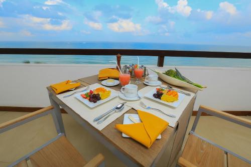 a table with food on a balcony with the ocean at Pandanus Beach Resort & Spa in Bentota