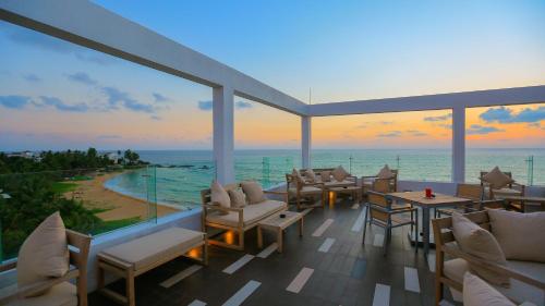 a balcony with a view of the ocean at sunset at Pandanus Beach Resort & Spa in Bentota