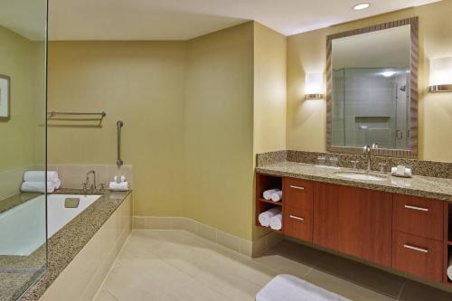 La salle de bains est pourvue d'une baignoire, d'un lavabo et d'un miroir. dans l'établissement Renaissance Las Vegas Hotel, à Las Vegas