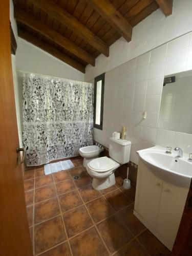 uma casa de banho com um WC branco e um lavatório. em HUILEN REST em Luján de Cuyo