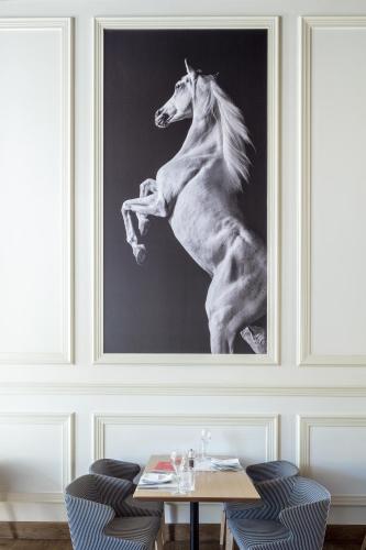 a painting of a horse jumping in front of a table at 3 Sixty Hotel & Suites in Nafplio