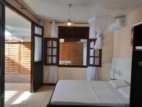 a bedroom with a bed and a open door at Vacances martinique in Sainte-Anne