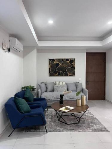 a living room with two blue chairs and a couch at Precioso departamento cerca de Plaza Galerías in Guadalajara