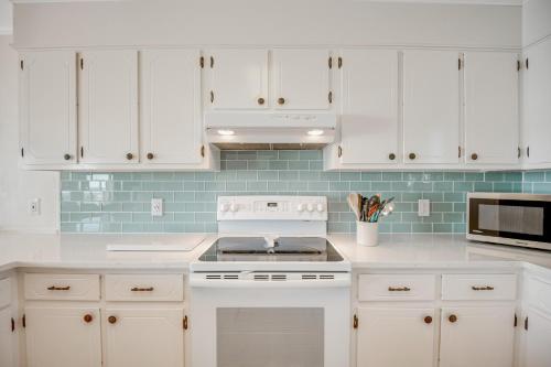 a kitchen with white cabinets and a stove top oven at Armstrong in Surf City