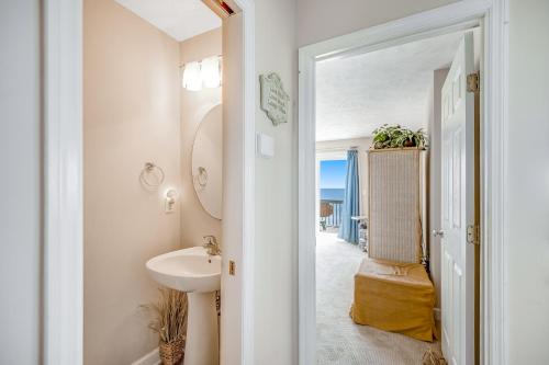 een witte badkamer met een wastafel en een spiegel bij Shore Sensation in Surf City
