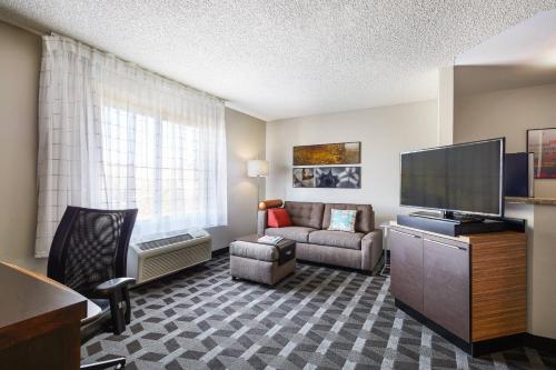a living room with a couch and a flat screen tv at TownePlace Suites Tempe at Arizona Mills Mall in Tempe