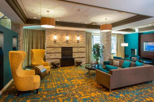 a lobby with couches and chairs and a fireplace at Residence Inn by Marriott Moncton in Moncton