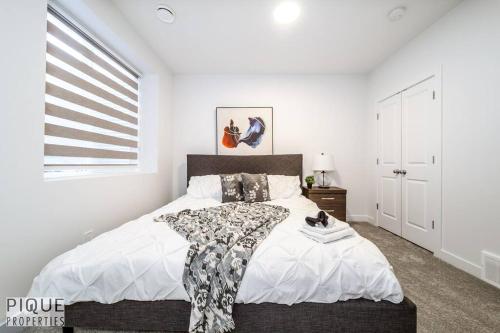 a bedroom with a large bed and a window at *NEW* Modern Suite King Bed! Netflix! Sleeps 4! in Edmonton