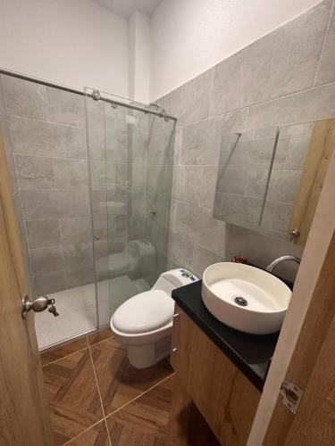 een badkamer met een toilet, een wastafel en een douche bij Apartamento nuevo en Coveñas in Coveñas