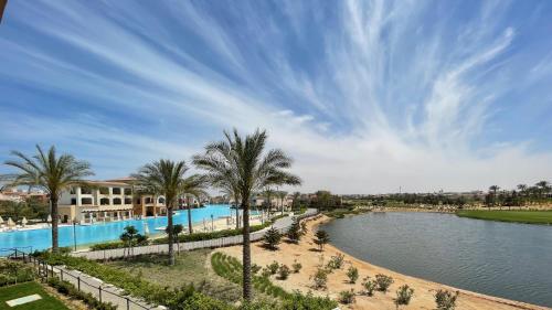 ein Resort mit einem Pool und Palmen in der Unterkunft The Penthouse in Marassi in El-Alamein