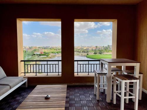 um quarto com uma grande janela com uma mesa e bancos em The Penthouse in Marassi em El Alamein