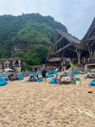 a group of people sitting on a beach at PINOKKIO B&B Restaurant in Jimbaran