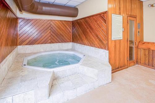 a jacuzzi tub in a room with wooden walls at Mountain Village 5H Unit A in Dover