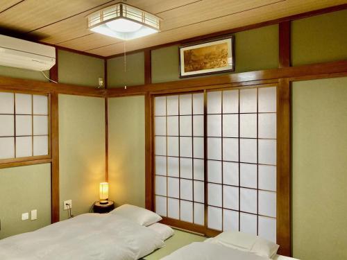 a room with two beds and a lamp and windows at Ikebukuro Sta 8 mins Good Access Modern House TS0318 in Tokyo