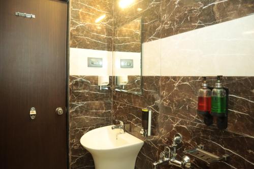 y baño con lavabo y espejo. en K Plus Comforts, en Kārwār