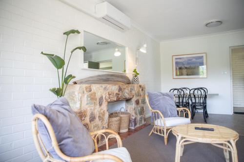 a living room with a fireplace and a table and chairs at Harriet House Tumut in Tumut