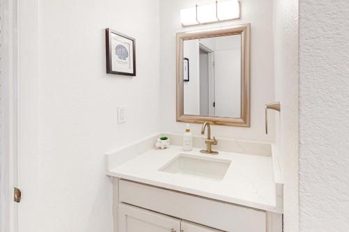 a white bathroom with a sink and a mirror at Gulf Terrace #256 in Destin