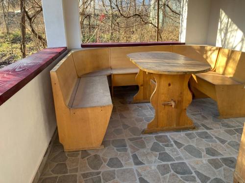 a wooden bench and a table and a window at Gradina Bio AMURTEL 