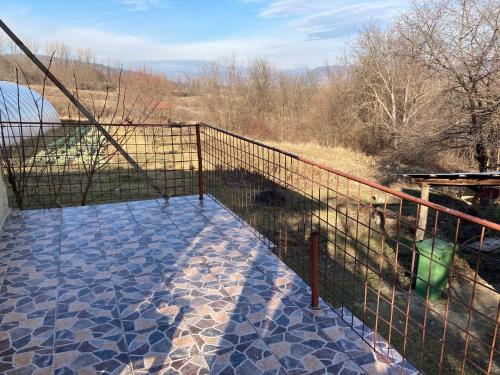 a balcony with a fence and a view of a field at Gradina Bio AMURTEL 