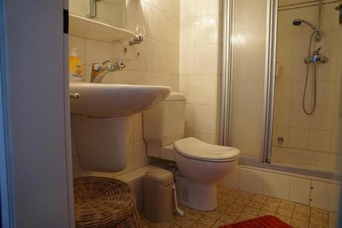 y baño con lavabo, aseo y ducha. en Haus Seehund FeWo 16, en Cuxhaven