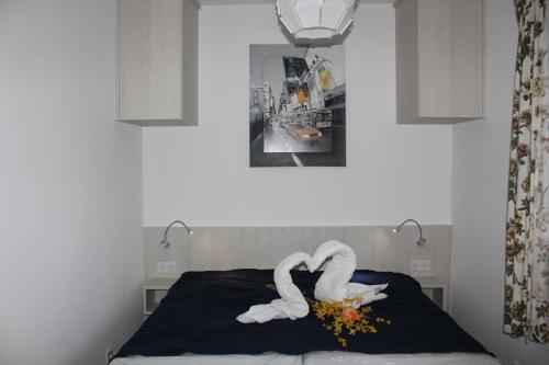 una cama con dos cisnes hechos de toallas en Haus Seehund FeWo 16, en Cuxhaven