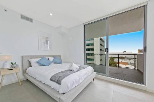 a bedroom with a bed and a large window at Aircabin｜Mascot｜Spacious & Modern｜Walk to station in Sydney
