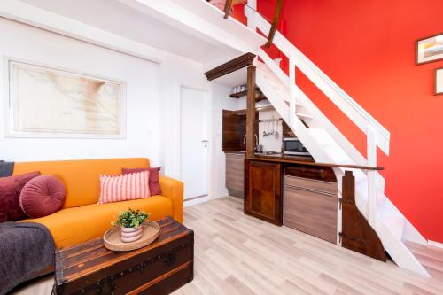 a living room with an orange couch and a staircase at Loreto LYA SEA VIEW APARTMENTS in Rovinj