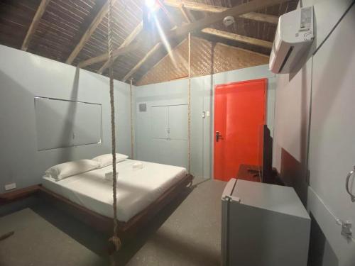 1 dormitorio con 1 cama y puerta roja en The Bangka Beach Guesthouse en Siquijor