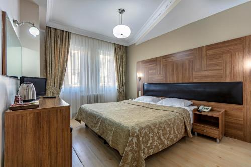 a hotel room with a bed and a television at Elasophia Hotel in Istanbul