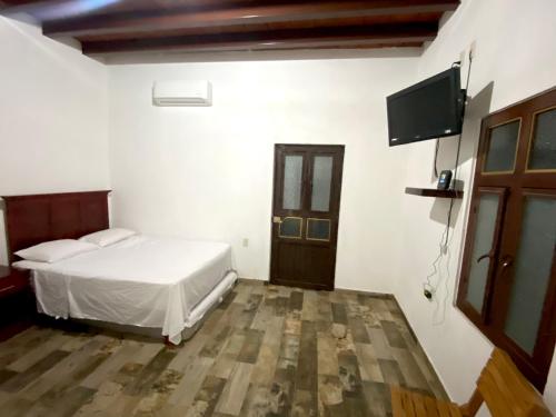 a bedroom with a bed and a flat screen tv at Departamento Frente a la Plaza Principal Jala in Jala