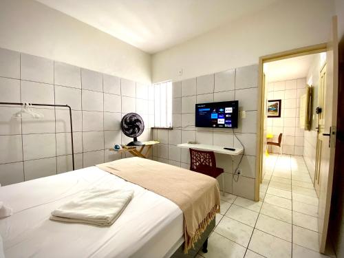 a bedroom with a bed and a bathroom with a television at 202 Kitnet no centro com wifi in Aracaju