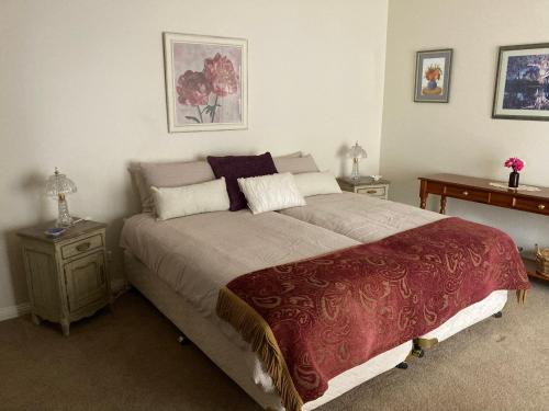 a bedroom with a large bed and two tables at Rosewood Park Guest Suite in Yarragon