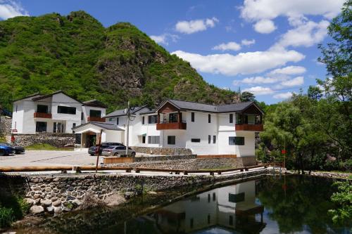 Xinglong的住宿－星宿-雾灵山居-民宿度假村，山前有水的房屋