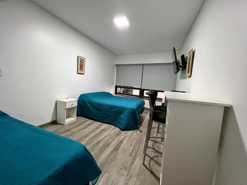 Habitación pequeña con 2 camas y escritorio. en Av. Corrientes 820, Obelisco II en Buenos Aires