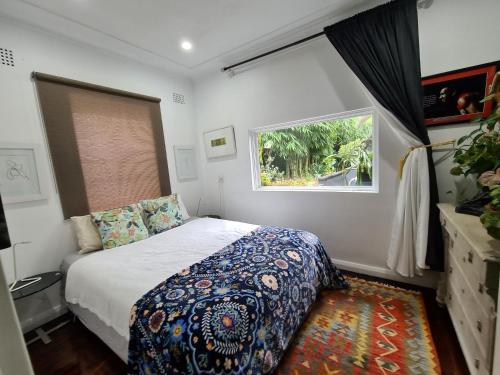 a small bedroom with a bed and a window at Vista Unit + Bamboo House Close to the City & Airport & Train station and Brighton Le Sands Beach in Sydney