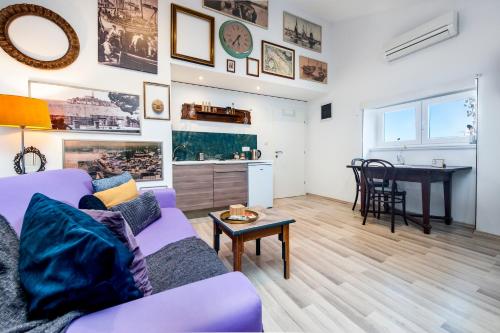 uma sala de estar com um sofá roxo e uma mesa em Loreto LYA SEA VIEW APARTMENTS em Rovinj