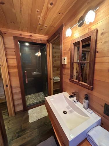 a bathroom with a white sink and a mirror at WOODY - Chalets de Môh in La Malbaie