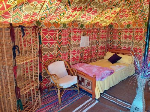 a room with a bed and a chair in a tent at استارز كامب in Bawiti