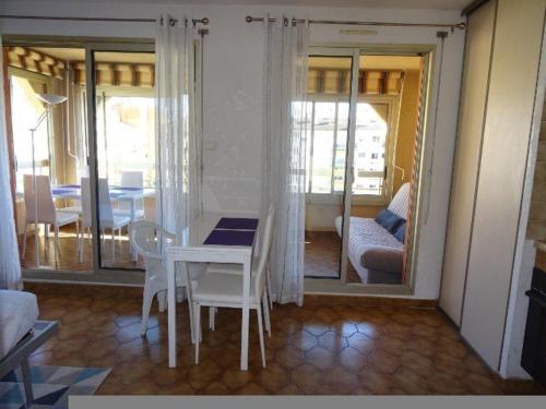 une salle à manger avec une table et des chaises et un salon dans l'établissement Appartement à Hyères avec parking, véranda et cuisine équipée - FR-1-335-177, à Hyères