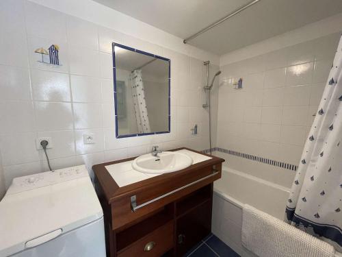 une salle de bain avec un lavabo, un miroir et une baignoire dans l'établissement Maison avec Piscine Chauffée, Terrasse et Parking à 300m de l'Océan - FR-1-224C-219, à Saint-Hilaire-de-Riez