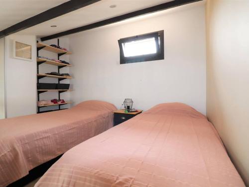 deux lits dans une chambre avec une fenêtre dans l'établissement Maison clim. proche mer, terrasse et parking privatisé, 6 pers. - FR-1-307-230, au Grau-du-Roi