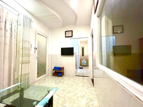 einen Flur mit einem Glastisch in einem Zimmer in der Unterkunft ALOHA HOTEL SUỐI MÂY PHÚ QUỐC in Phu Quoc
